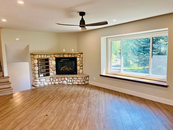 Living room anchored by a stone fireplace