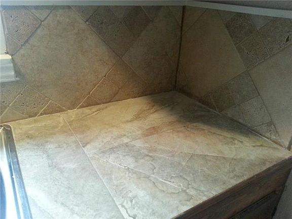 Kitchen counter tops and back splash are ceramic with tumble