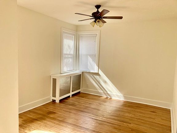 Dining room with southern exposure and ceiling fan. Freshly redone hardwood floors.
