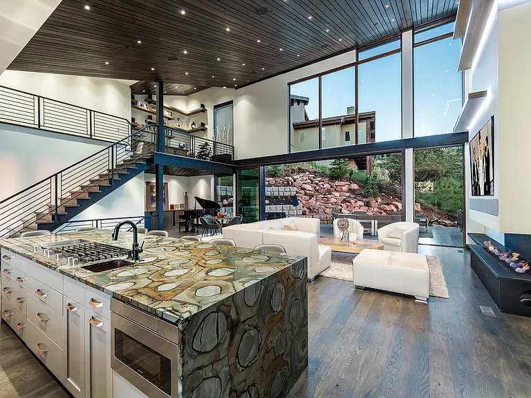 large living room with 85" TV, and 25' multi slide doors with bug screen, outdoor seating area
