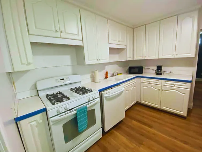 Fully equipped kitchen featuring a stove, oven, microwave, refrigerator and cabinetry.