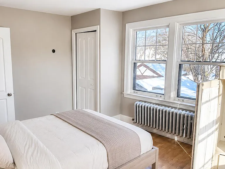 Furnished bedroom with a full bed, hardwood floors, double windows, and a closet for convenient everyday storage.