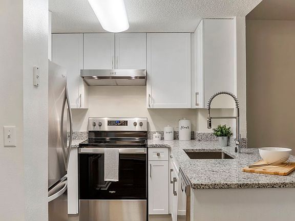 Renovated Package II kitchen with white cabinetry, quartz countertops, stainless steel appliances, and hard surface flooring