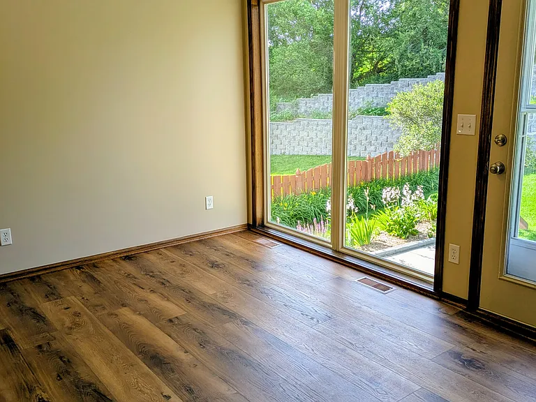 Dining area with vaulted ceiling and a door to the patio.