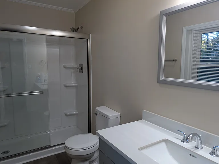 Master bathroom. New walk in shower, new vanity and toilet with new window overlooking backyard