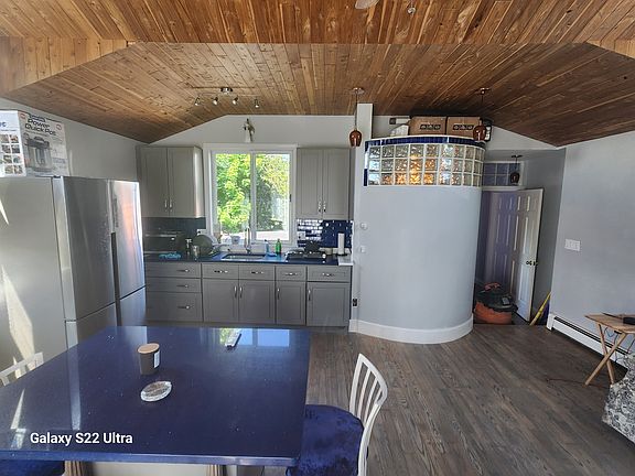 View shows curved shower wall & slider window over sink