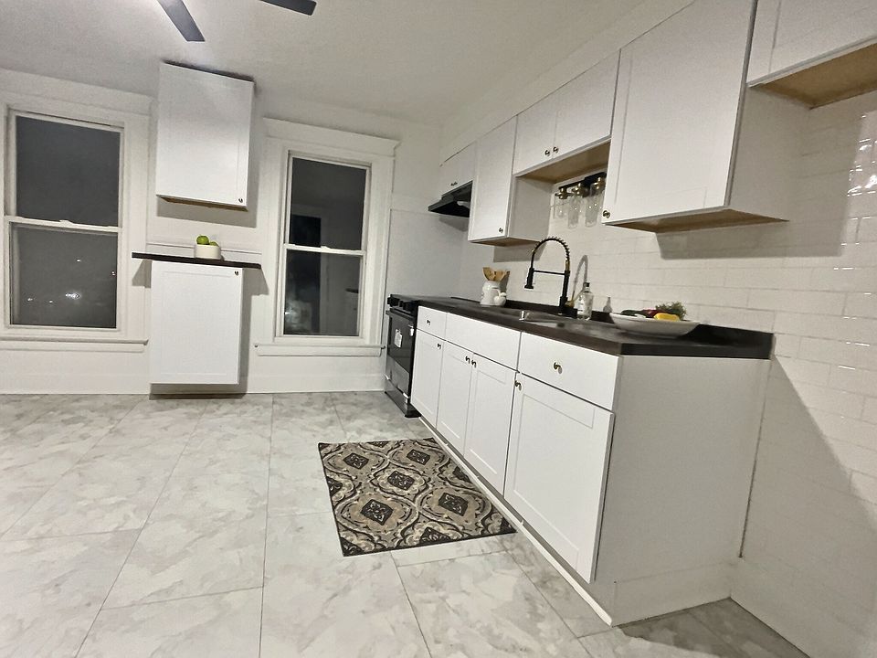 spacious newly remodeled eat in kitchen with modern white subway tile, waterproof vinyl flooring new glass top stove and over the range microwave