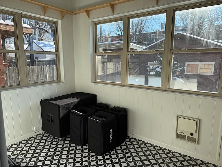 Sunroom with wall to wall windows and plant shelving