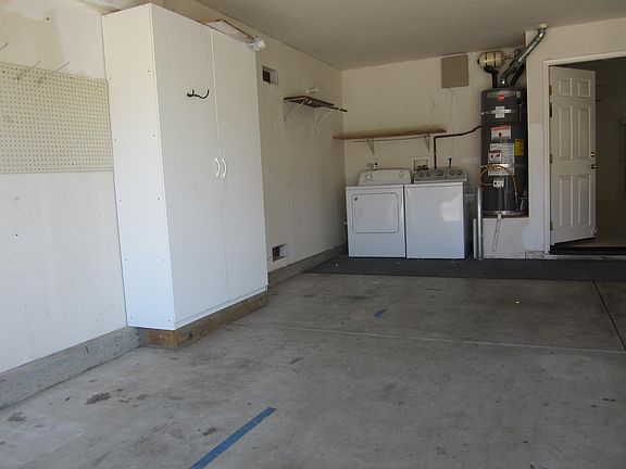 Showing additional enclosd shelving along with the washer/dryer corner of the garage. Owner supplies and maintains these.