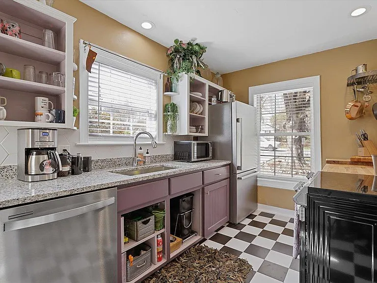 Kitchen at Hunsucker's was completely remodeled in 2023 and features stainless appliances and checkerboard tile floor all within walking distance of Downtown and Cone Hospital