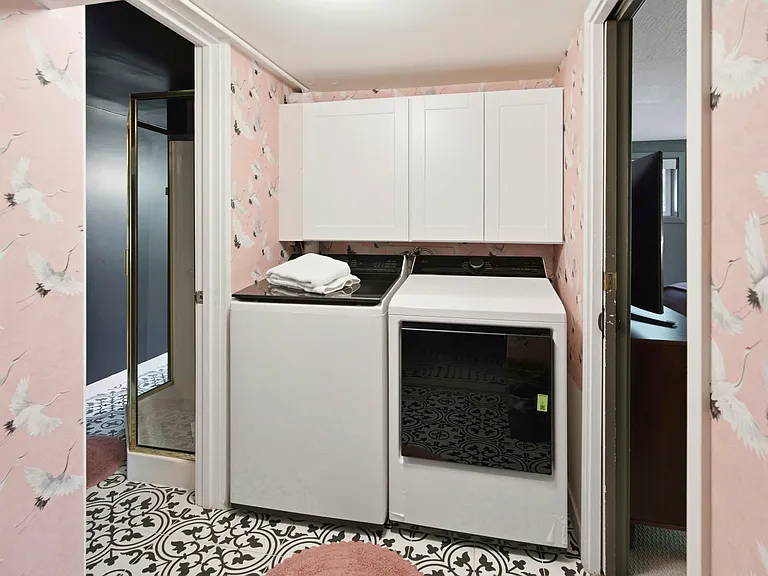Laundry room downstairs. There is a bathroom to the right with a shower and to the left is the fourth bedroom with a full bathroom.