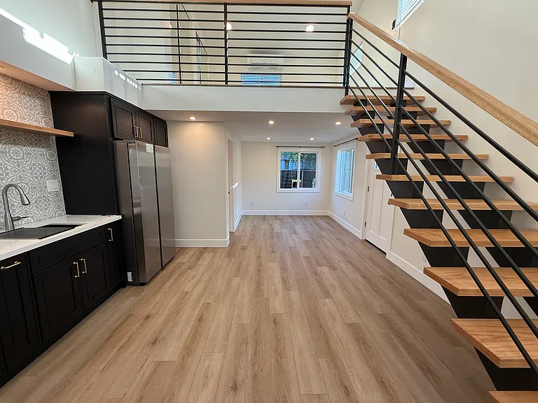 View of length of unit with stairs up to loft