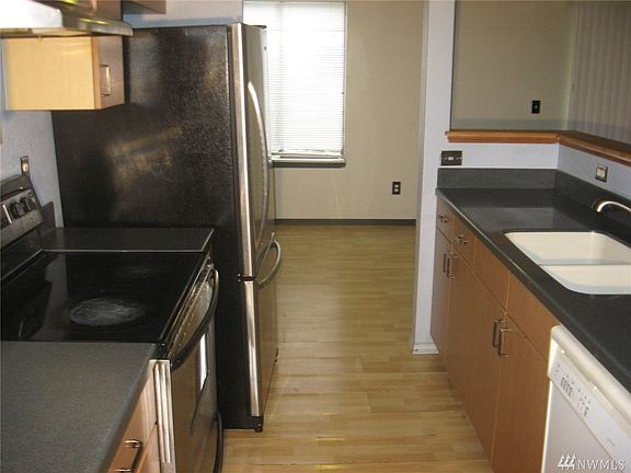 Kitchen with appliances. Cabinets in good condition, but laminate flooring must be replaced.