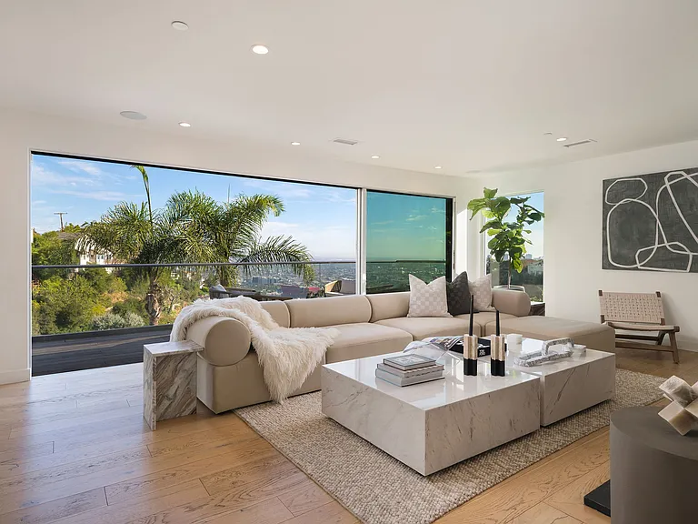 1st floor living room lounge with floor to ceiling glass windows, balcony with seating, smart TV and fireplace.