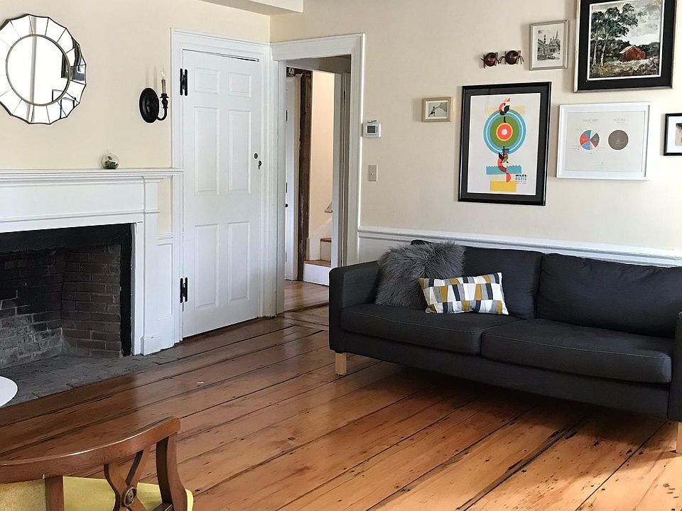 Living room with closet and doorway leading to kitchen and back stairs.