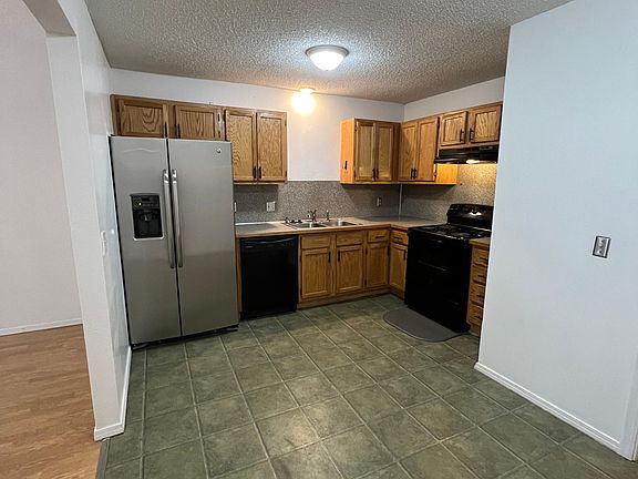 Kitchen has oven, refrigerator and dishwasher