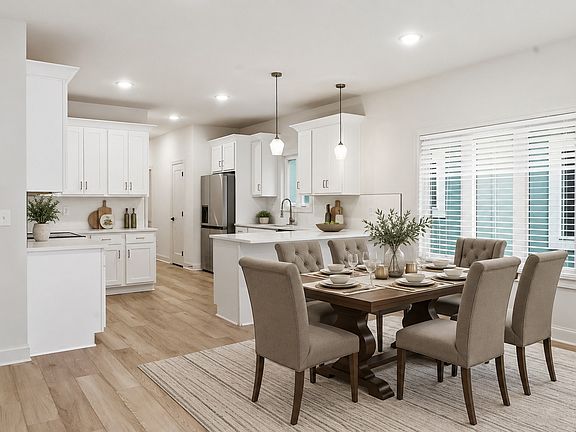 Dining area next to the kitchen with large windows and open access to the living space. Photo is virtually staged.