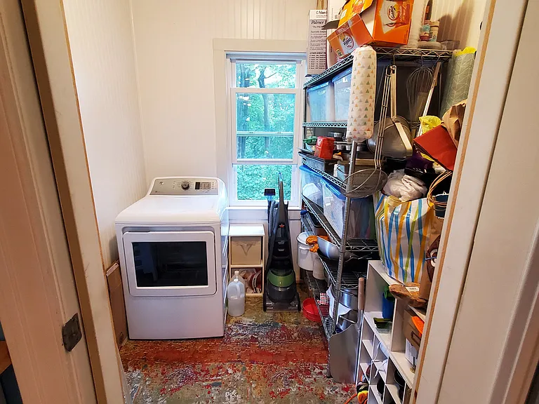Dryer is on back porch behind pantry (shelves not part of unit). Ample extra storage space.