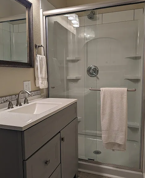 Upstairs bathroom shower and vanity.