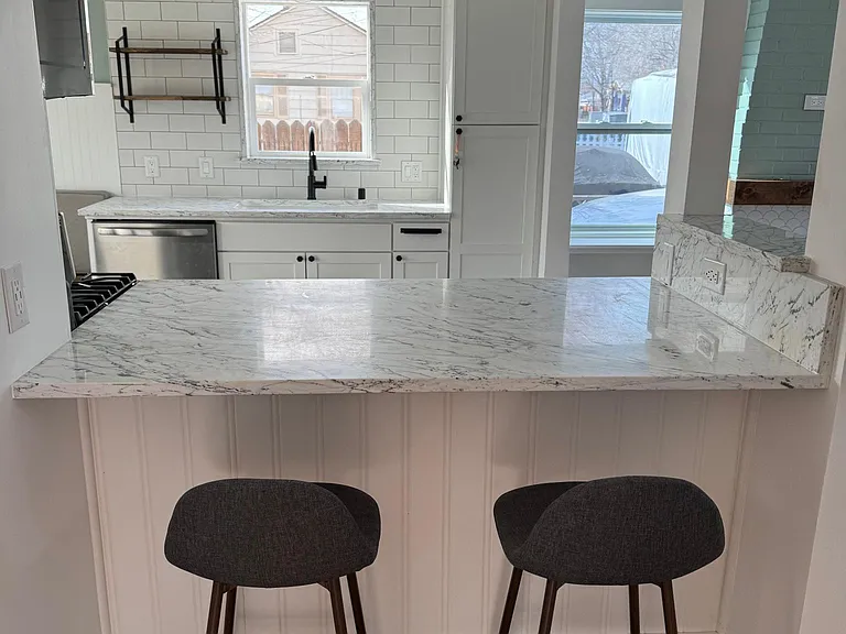 Breakfast bar in kitchen and living room area. Barstools stay with property.