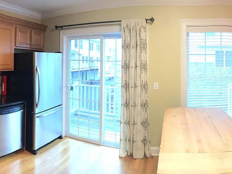 Kitchen with custom built in banquet with cushions, corner cabinets for extra storage and a butcher block island on casters for flexible floor plan.