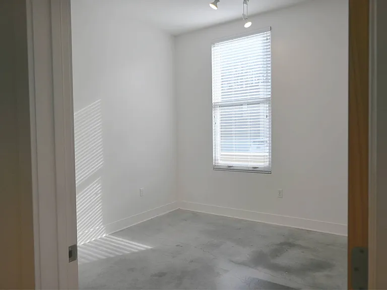Bedroom in a unit with white walls at The Sawyer.