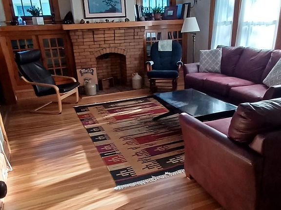 This bright living room has original oak trim, high ceilings, leaded windows, (non-working) fireplace and built in book cases