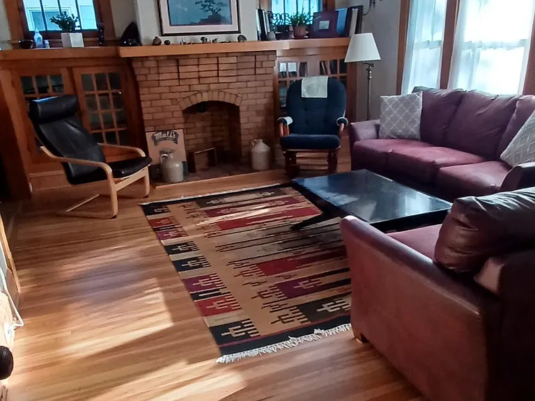 This bright living room has original oak trim, high ceilings, leaded windows, (non-working) fireplace and built in book cases