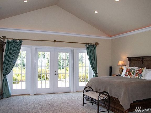 Master bedroom looks out through French doors leading to view deck