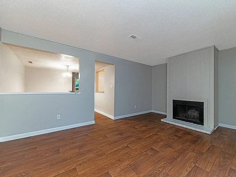 Spacious living room with hardwood-style flooring & fireplace