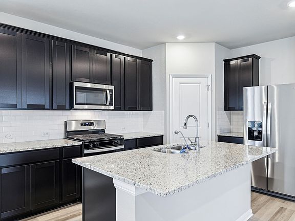 This kitchen features Espresso-colored cabinets and granite countertops.