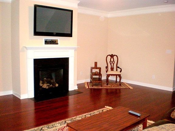 Open living room wth lots of windows, fire place and hardwood floors