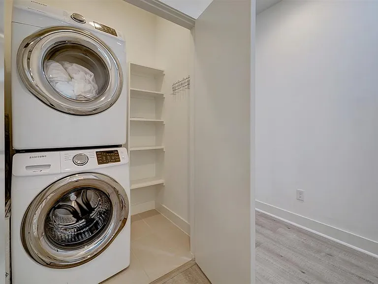 Utility closet with stacked washer and dryer across from the master bedroom.