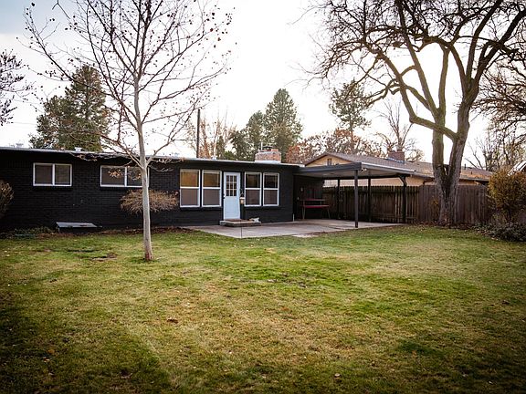 Fully fenced backyard with partially covered patio.