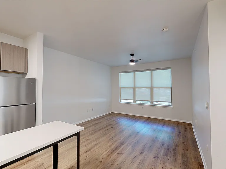 Apartment dining and living room with wood-style flooring.