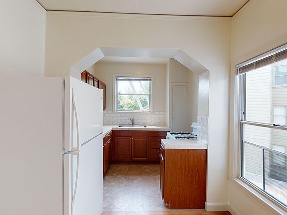 Kitchen with cabinets, refrigerator, stove, and sink