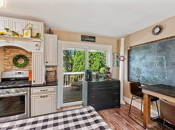 New engineered wood flooring, table space, and newer sliding glass door to the two-tiered deck to en