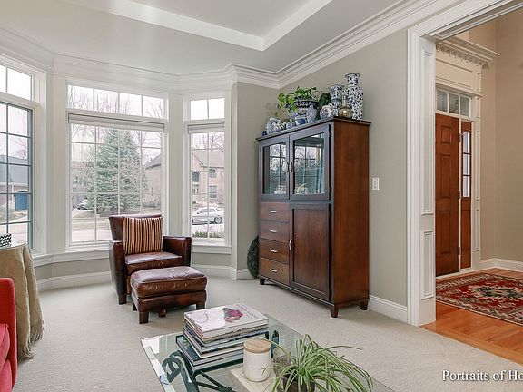 Formal living room with neutral carpeting, tray ce