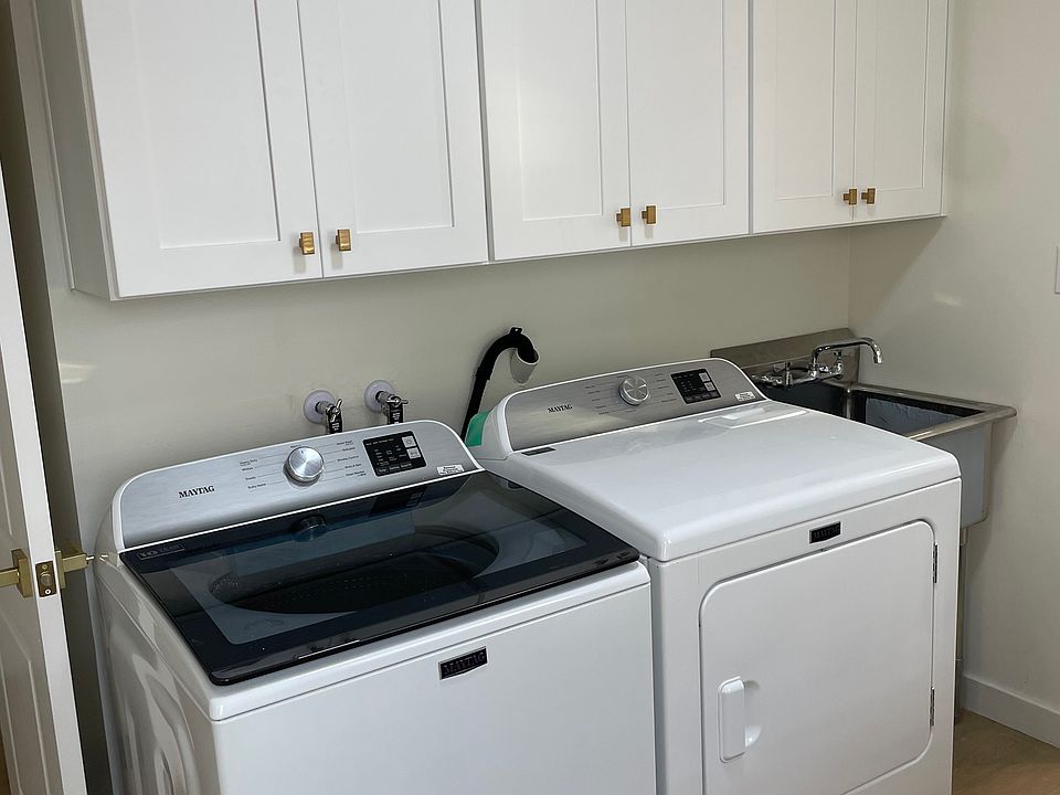 custom cabinetry, quartz countertop, utility sink, and wall-mounted shelves