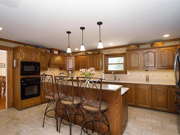 Beautifully updated kitchen with tile flooring, granite counter tops, back splash, lighting, etc.