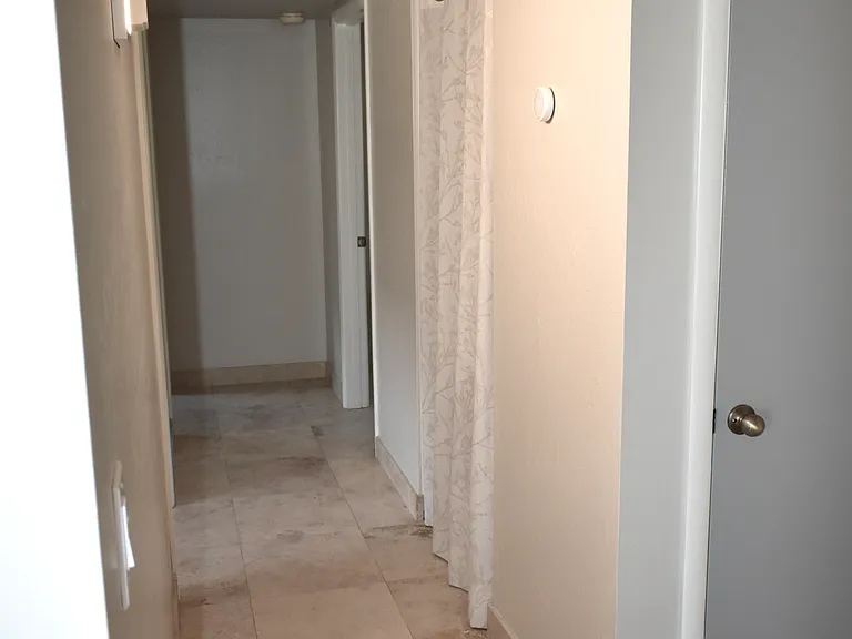 View down the Hallway from the Living Room. The door on the right is a coat closet and the secondary all leads to the Hall Bathroom.