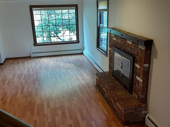 View of living room looking towards front of home. Large bright windows bring in natural light.