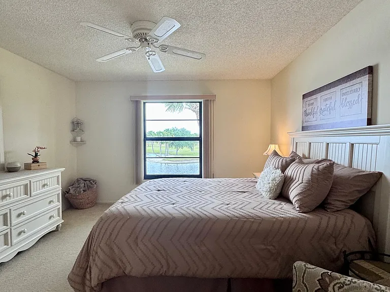 Spacious Primary Bedroom w/ stunning expansive lake & golf course views + a HUGE walk-in closet & walk-in shower!
