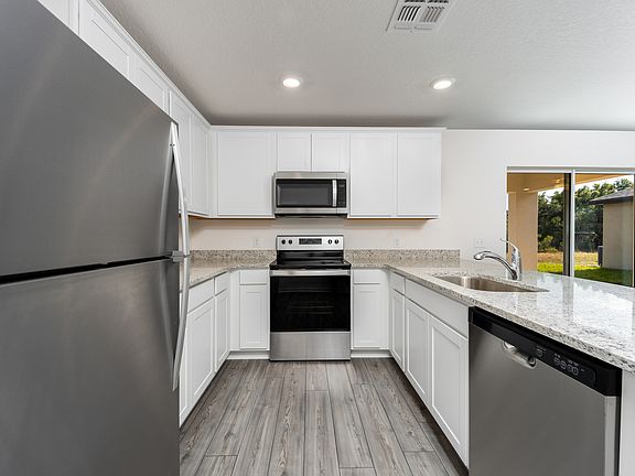 The kitchen features stainless steel appliances and granite countertops.