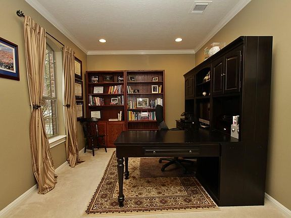 The Study offers a private space with plush carpet and decorator colors with white crown molding and inset lights.