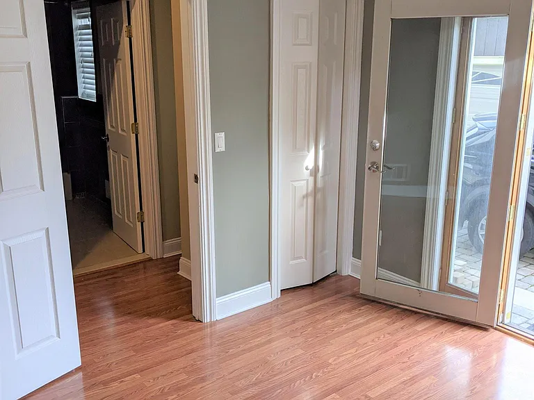 Another shot of bedroom with bathroom across the hallway, closet, and rear entrance