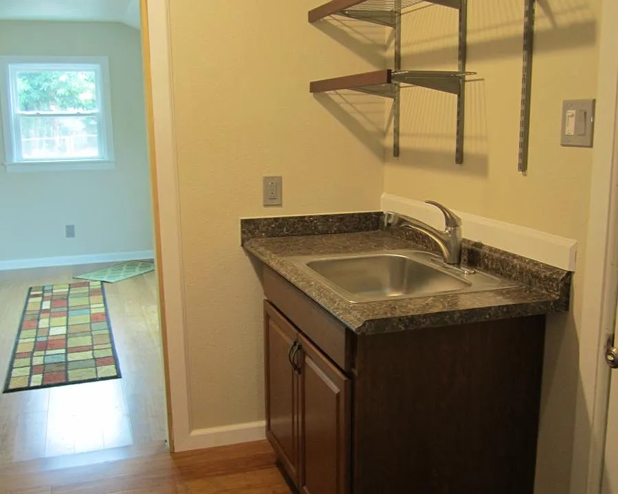 Pull out faucet with storage shelving above