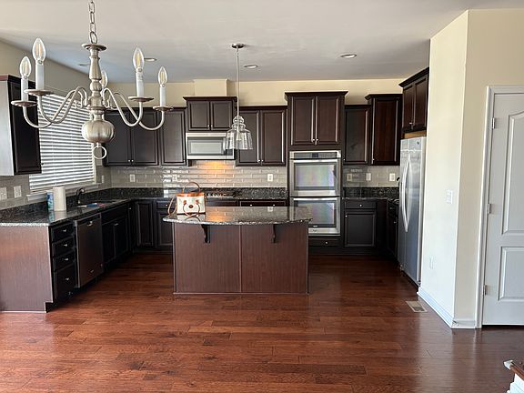 Gourmet kitchen with double oven, granite countertops, tiled backsplash, s/s appliances, and lots of storage.