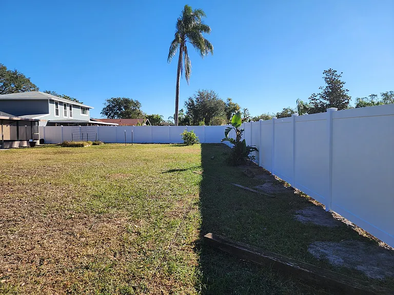 Large, fully fenced backyard with a newly installed vinyl privacy fence, perfect for outdoor entertaining, children, or pets