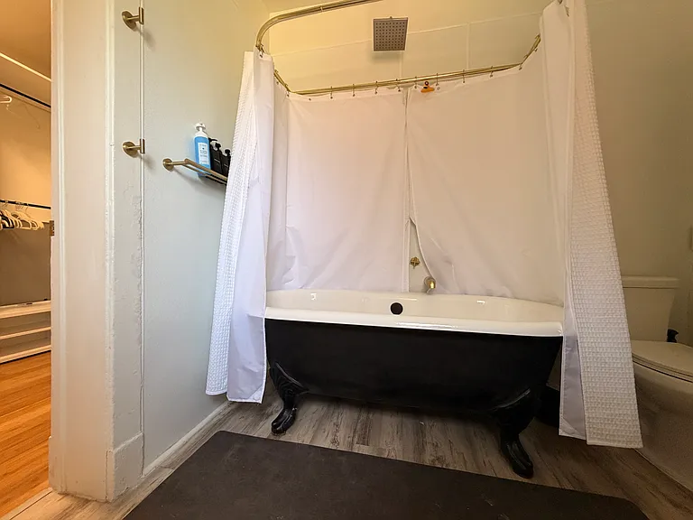 Primary bathroom with clawfoot tub and rain shower